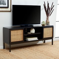 a flat screen tv sitting on top of a wooden entertainment center in a living room