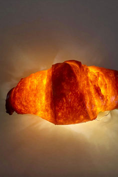 a large piece of bread sitting on top of a white table next to a light