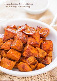 a white bowl filled with sweet potatoes on top of a table