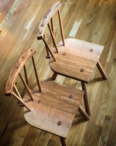 three wooden chairs sitting on top of a hard wood floor