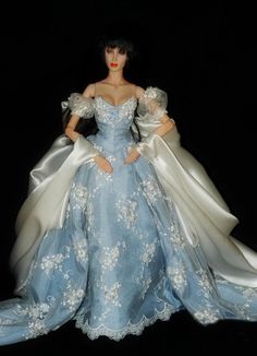 a doll dressed in blue and white is posed