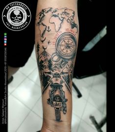 a man's arm with a compass and world map on the back of it