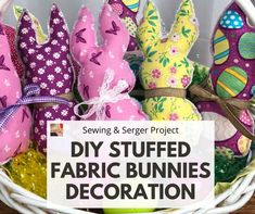 a basket filled with stuffed fabric bunnies sitting on top of a wooden table