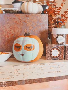 an orange pumpkin sitting on top of a shelf next to some other decorations and items