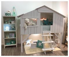 a child's room with a white wooden house bed and toys on the floor