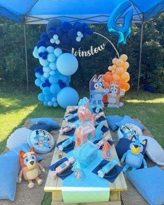 a table set up with balloons, plates and other items for an animal themed birthday party