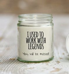 a glass jar with some writing on it next to a small white bowl full of yogurt