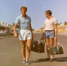 two people walking down the street with luggage