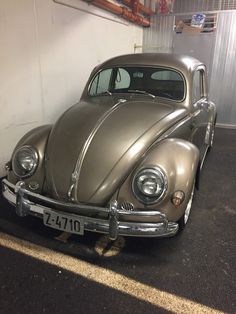 an old vw bug parked in a garage