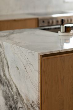 a marble counter top in a kitchen with wooden cabinets