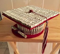 a graduation cap made out of money sitting on top of a wooden table