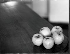 four apples sitting on top of a wooden table