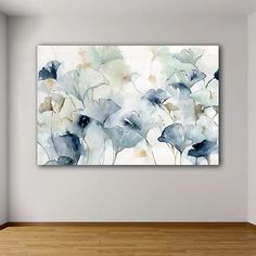 an abstract floral painting hangs on the wall in a room with hardwood floors and white walls