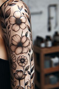 a woman's arm with flowers and leaves tattooed on the back of her body