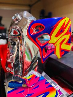 a close up of a motorcycle helmet on a table with other items in the background