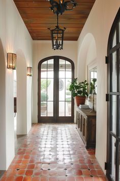 an entry way with brick tiles and arched doors