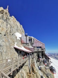 a ski lift going up the side of a mountain with snow on it and mountains in the background