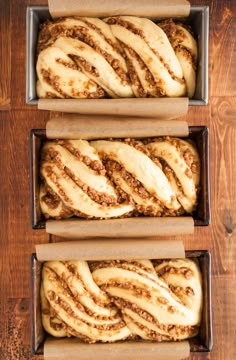 three loafs of cinnamon swirl bread sitting on top of a wooden table next to each other