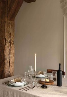 a table set for two with plates and wine glasses