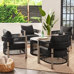 a living room filled with black furniture and a plant in the middle of the room