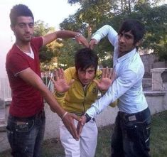 three young men standing next to each other with their hands in the shape of a heart