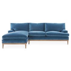 a blue sectional couch sitting on top of a white floor next to a wooden frame