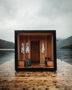 an outdoor sauna with towels hanging on the wall and two benches in front of it