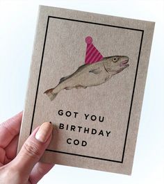 someone holding up a birthday card with a fish wearing a party hat and the words, got you birthday god