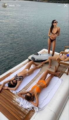 three women in bikinis lounging on the deck of a boat