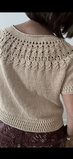 a woman is wearing a sweater with crochet on it