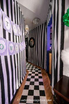 the hallway is decorated with black and white striped walls, green ribbon streamers, and decorations