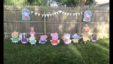 two boys are standing in front of some paper cutouts with peppa pig on them