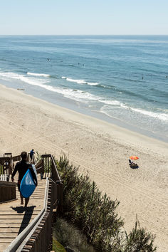 a person walking up stairs to the beach