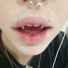 a woman with piercings on her nose wearing a necklace