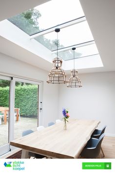 a dining room table with four chairs and a skylight in the ceiling above it