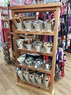 a wooden shelf filled with lots of metal buckets