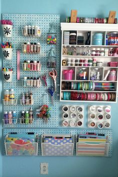 a peg board with lots of crafting supplies on it and hanging from the wall