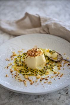 a white plate topped with dessert on top of a table next to a napkin and spoon