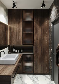 a modern bathroom with marble counter tops and wooden cabinetry, along with two sinks