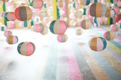 colorful balls are floating in the air on a striped surface with multicolored stripes