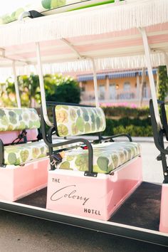 two pink and green chairs sitting on top of a golf cart