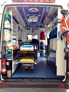 the inside of an ambulance with its doors open and medical supplies in the bed area