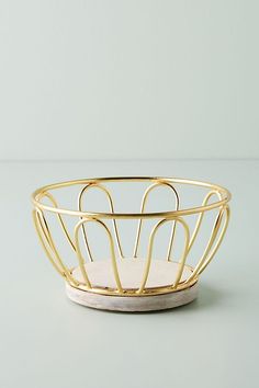 a gold wire bowl on a white surface