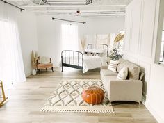 a living room filled with furniture and a bed in the corner on top of a hard wood floor