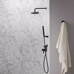 a bathroom with marbled walls and flooring next to a bathtub filled with white towels