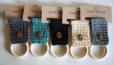 four crocheted wristbands with gold pineapple buttons on them, hanging from hooks