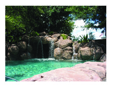 an outdoor pool with waterfall and rocks