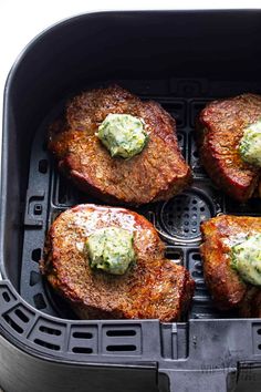 four steaks with green sauce in an air fryer