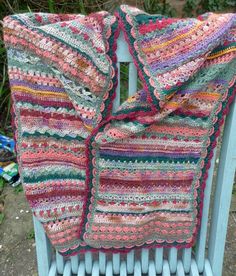 a crocheted blanket sitting on top of a blue bench