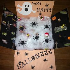 an open box filled with halloween decorations on top of a wooden floor